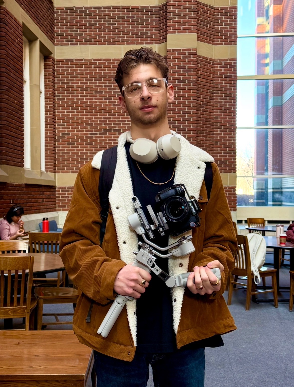 Costa holding camera equipment in a production setting
