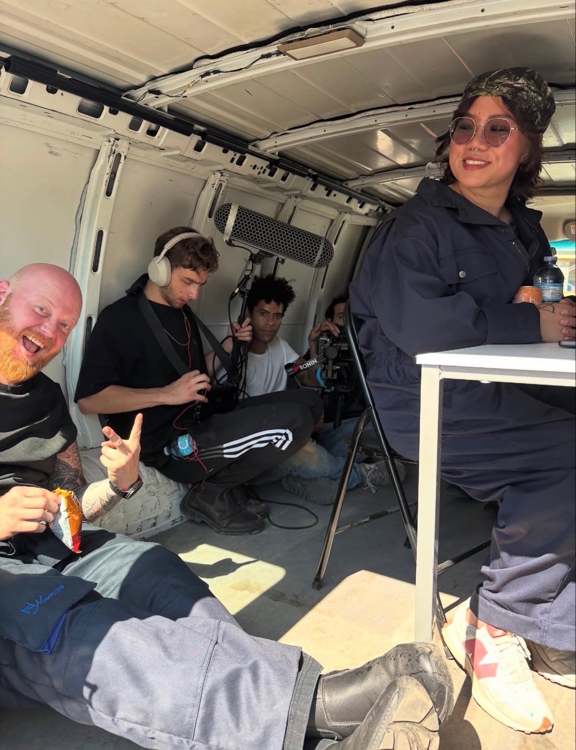 Costa working with sound gear on set inside a vehicle